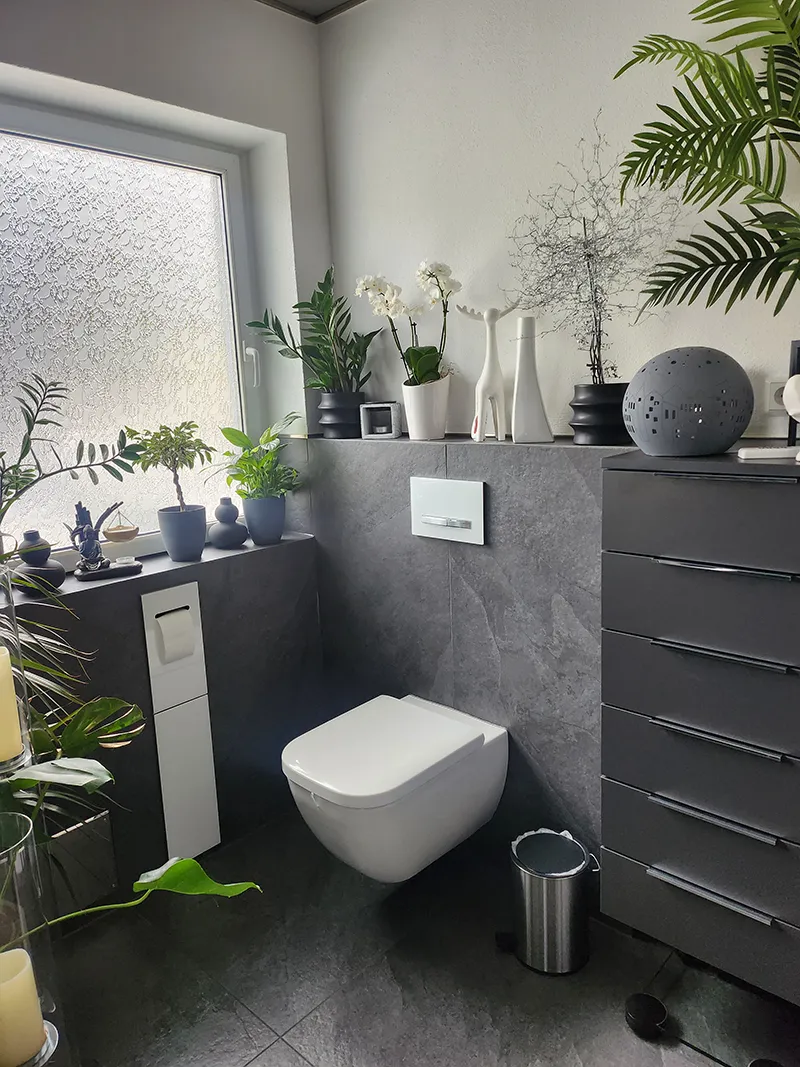 neu mit grauen Naturfliesen verlegter Toilettenbereich